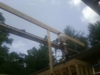 Carpenter setting a ridge beam over a new addition frame — Ice Dam Removal by Roofing Brothers in Vanderbilt