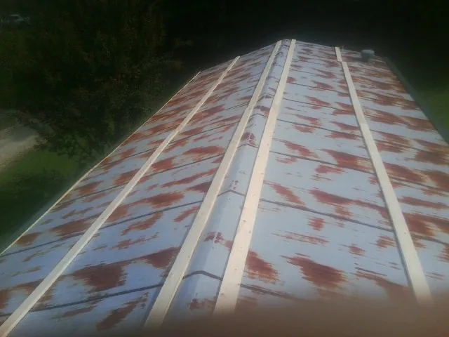 Rusted metal roof panels with new wood purlins before replacement — Storm Damage Roof Repair in Vanderbilt by Roofing Brothers